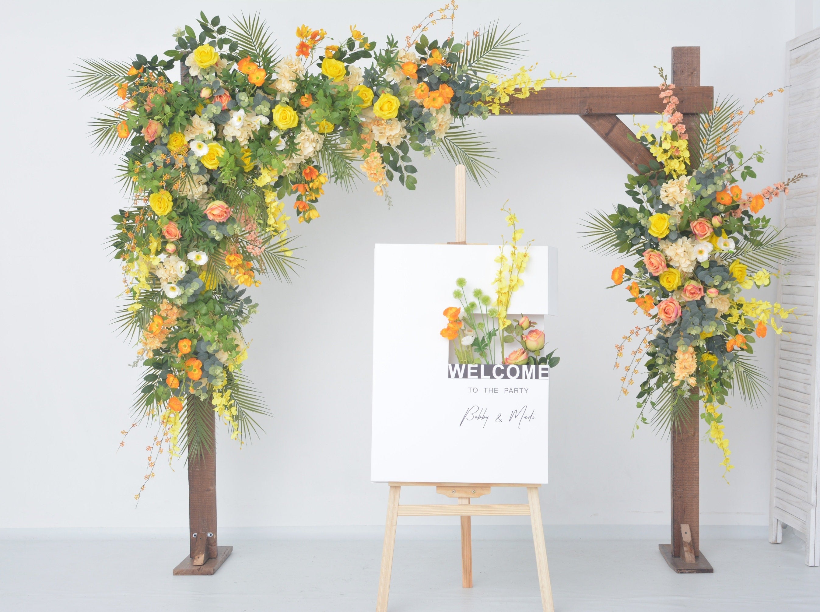 Lush Greenery Wedding Arch Decor with Yellow, Orange, and Champagne Floral Accents